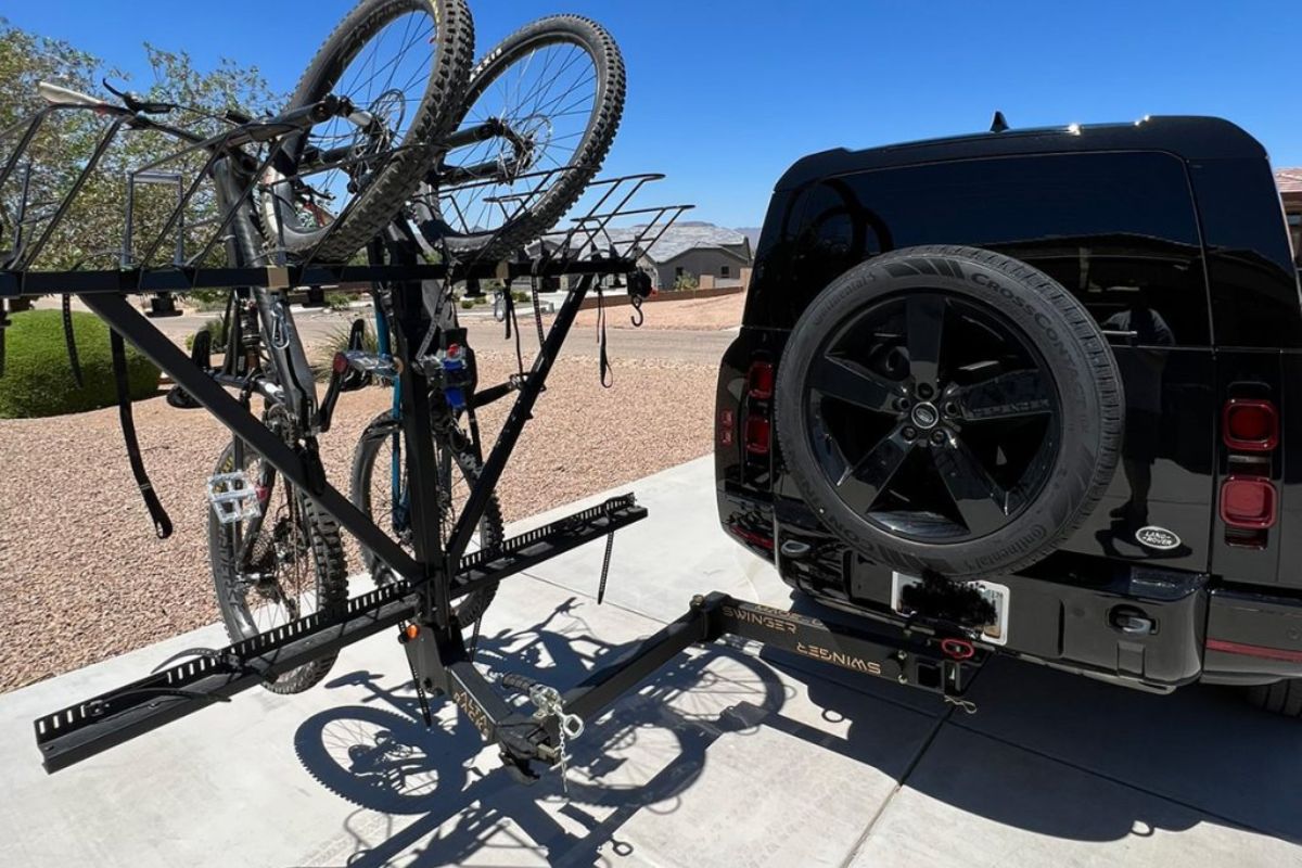 Alta Swinger vertical bike rack mounted on a black Land Rover Defender with multiple bikes